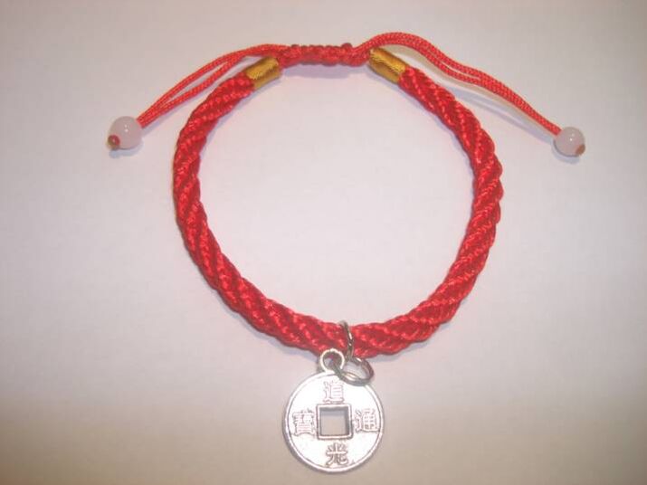 Red thread bracelet with rare coin to attract luck