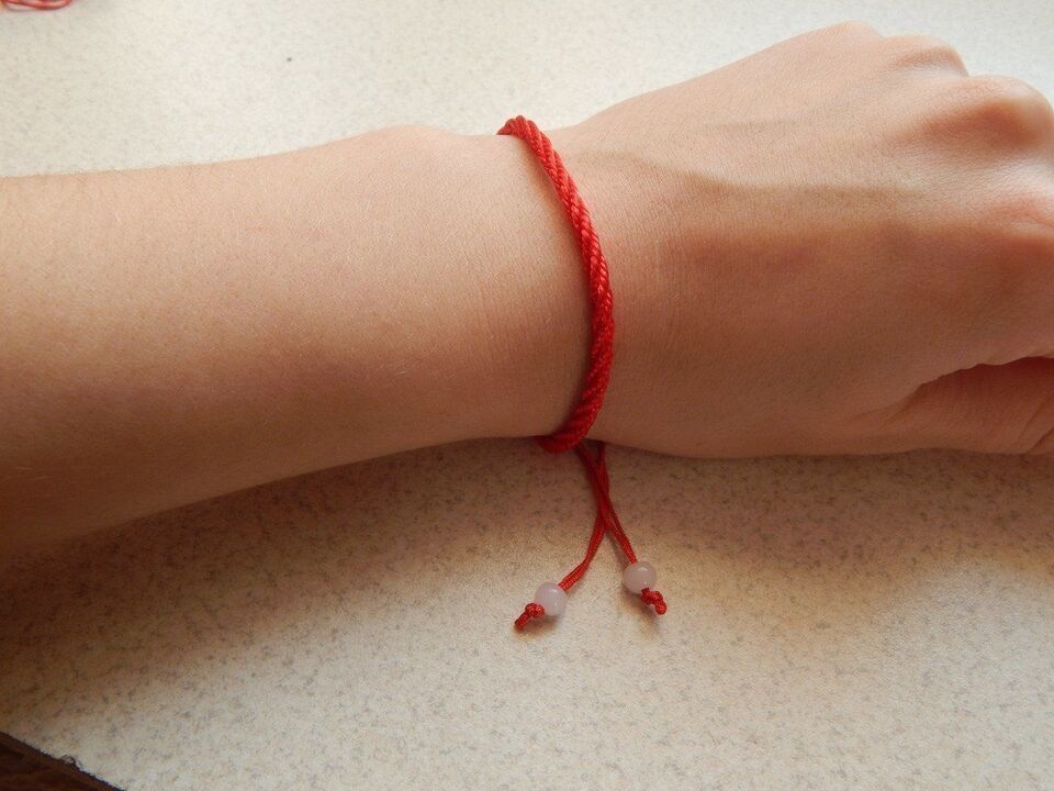 red thread on his wrist